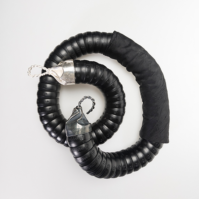 Heavy chain in black flexible industrial hose with cast silver clasps and silk fabric