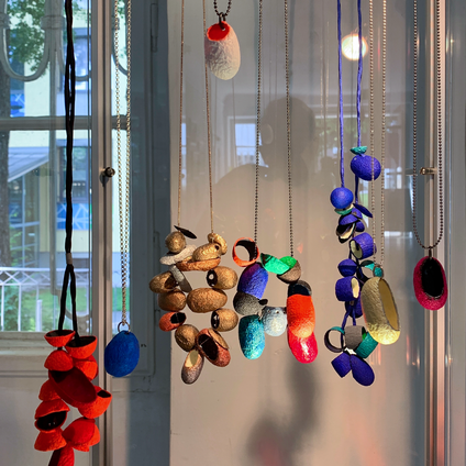 Exhibition display with many colorful cocoon necklaces