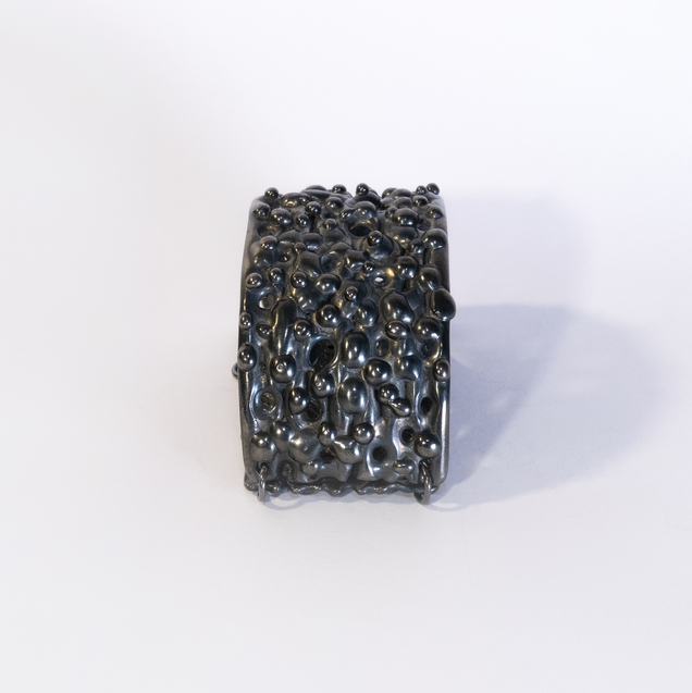 Blackened silver bangle with a nub surface texture like chameleon skin