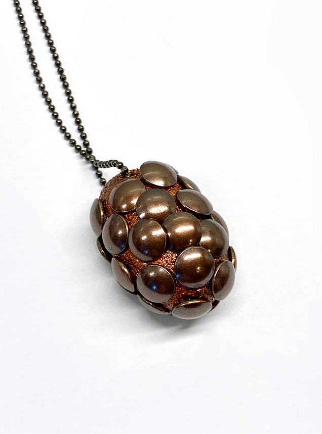 Schwarz rhodinierte Silberkette mit bronzefarbenem Seidenkokon, in den viele bronzefarbene halbrunde Nägel gestochen sind