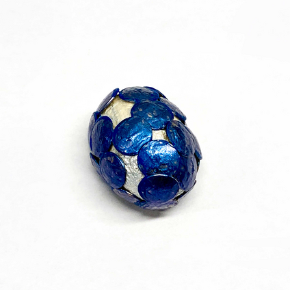 Pendant made of a half silver silk cocoon, pierced with many blue thumbtacks
