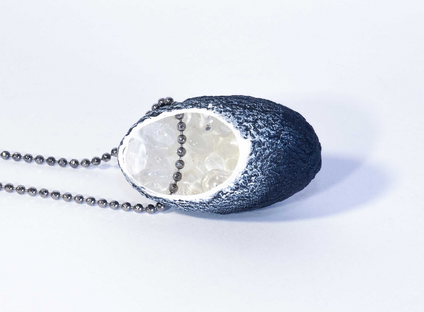 Necklace with a black silk cocoon pendant whose white inside is filled with small glass balls, the chain is made of silver