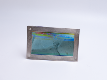 Irregular angular brooch with a silver frame and canvas in colourful fine stripes, it looks like a framed picture