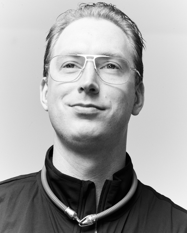 Artist Alexander Jackson Wyatt wears a necklaces and a black blouson and glasses