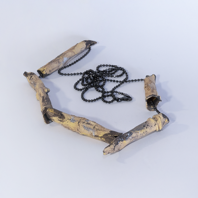 Black silver necklace with five tubes, looking like yellowish bamboo